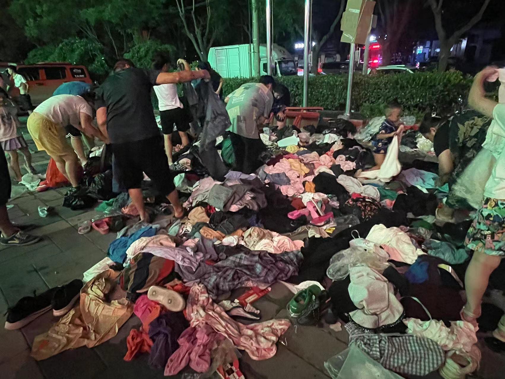 涿州路边现大量衣物供受灾群众挑选，有人称已5天没换洗，为全家人选衣服